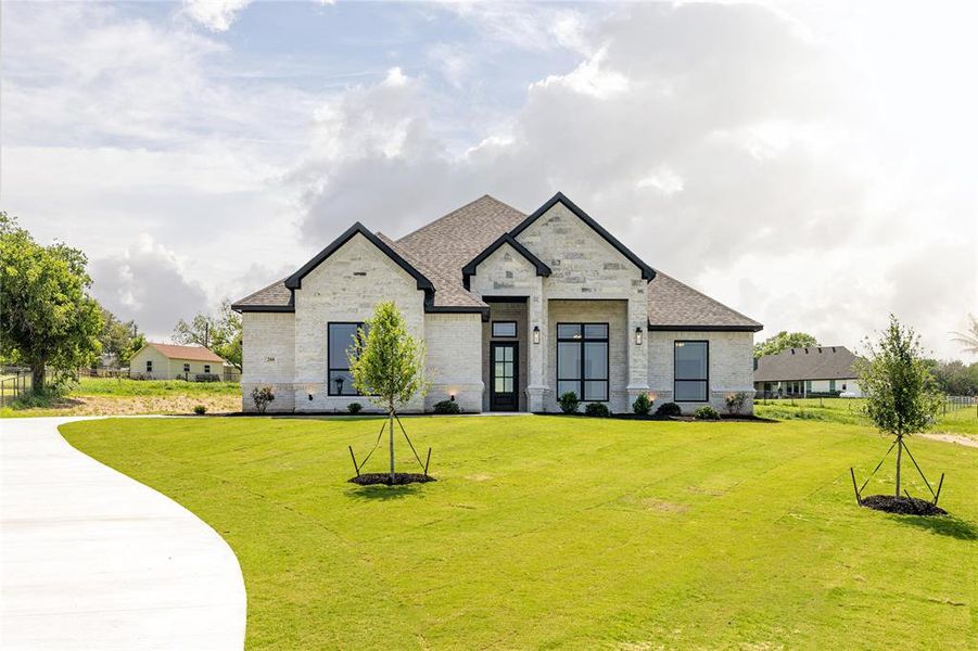 French country home featuring a front yard