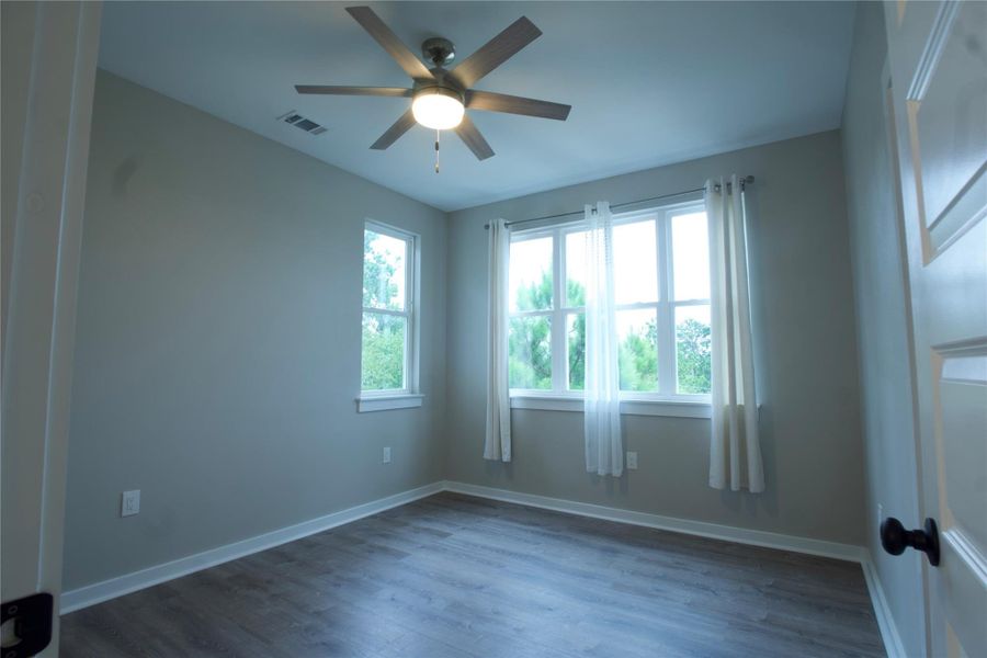 Bedroom with dark wood-style flooring and ceiling fan