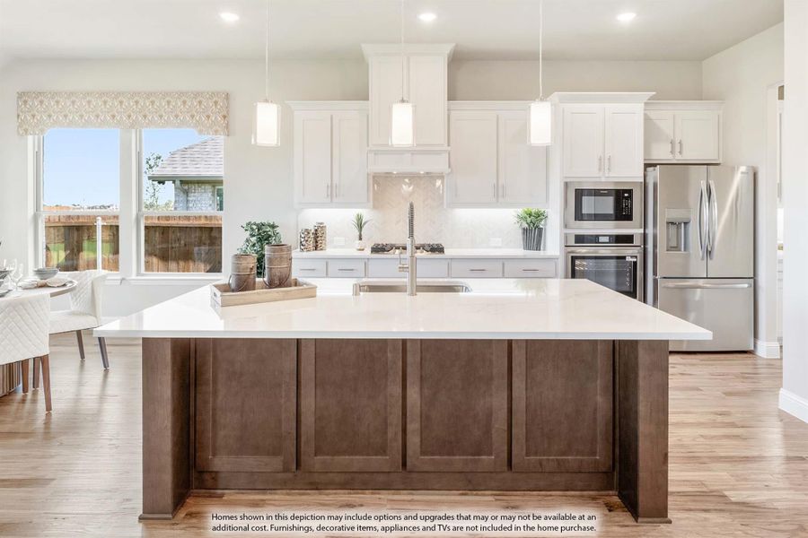 Kitchen with large dark wood island, white cabinets, pendant lights, and stainless steel appliances on hardwood floors Kitchen with large dark wood island, white cabinets, pendant lights, and stainless steel appliances on hardwood floors