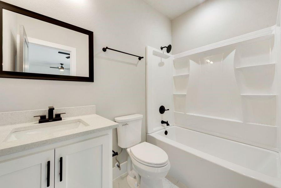 Full bathroom with shower / bathing tub combination, vanity, toilet, and ceiling fan