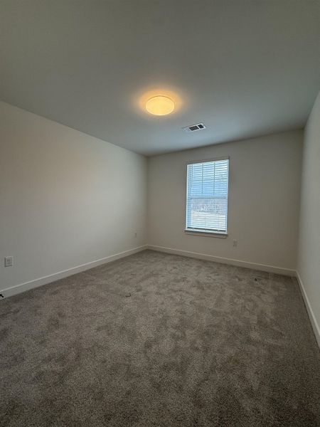 Spare room featuring light colored carpet and baseboards