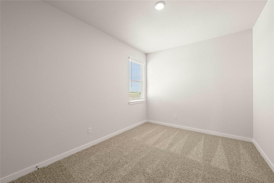 An inviting room awaits personal touches with fresh carpet and a sun-drenched window.