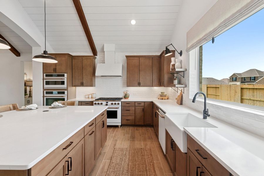 Stylish kitchen with chestnut brown cabinets and quartz counters (*Photo not of actual home and used for illustration purposes only.)