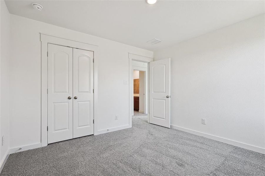 Unfurnished bedroom featuring light carpet and a closet