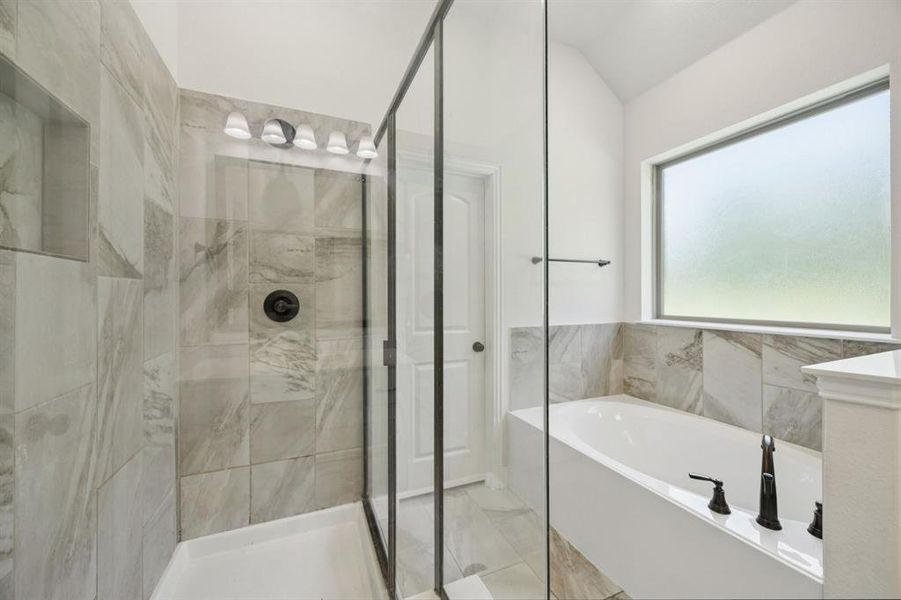 En-suite bathroom with marble like tiles, a separate shower, garden tub, separate vanities, and large walk-in closet.