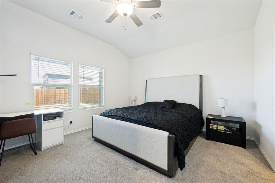 Carpeted room featuring a vaulted ceiling and a ceiling fan with light fixture Carpeted room featuring a vaulted ceiling and a ceiling fan with light fixture