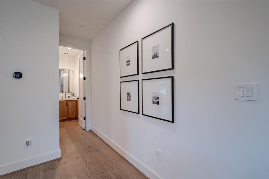 Corridor with light wood-style flooring and baseboards