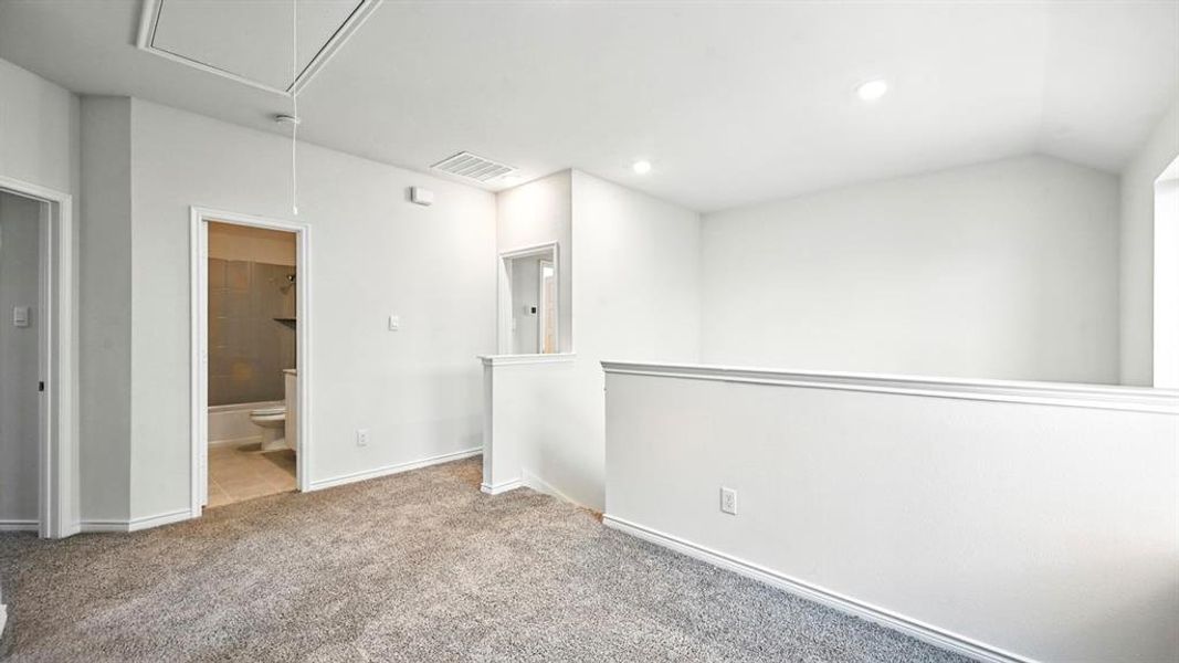 Unfurnished room featuring attic access, light colored carpet, and recessed lighting