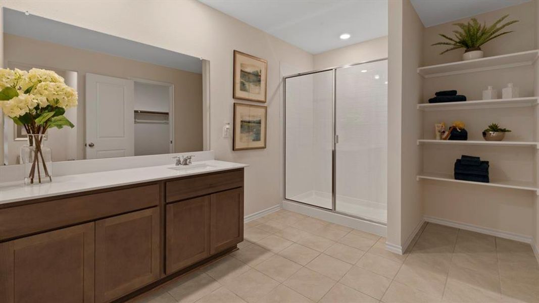 Full bathroom featuring vanity, a shower stall, a spacious closet, and light tile patterned floors