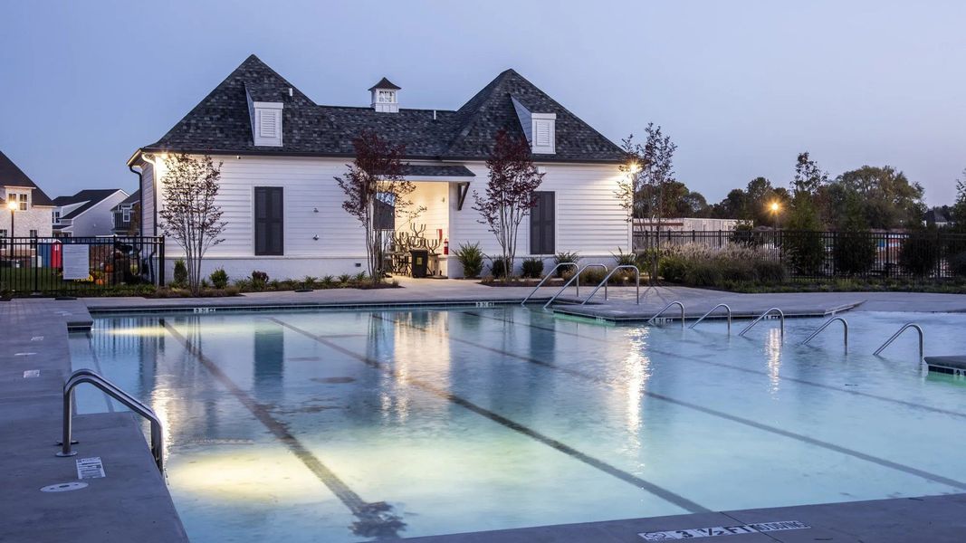 Large community pool with nighttime lighting