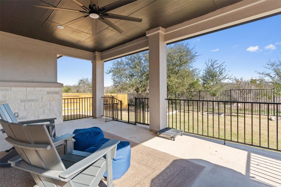 Fenced backyard featuring ceiling fan and a patio