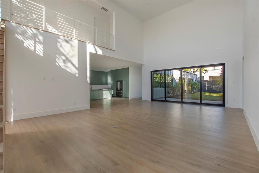 Unfurnished living room with a high ceiling and hardwood / wood-style floors