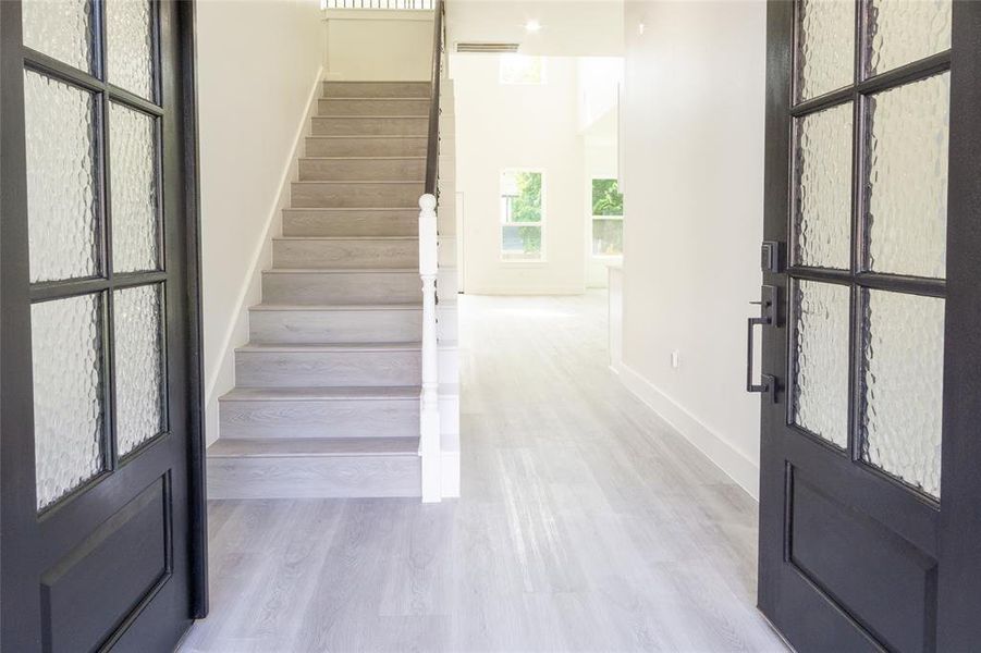Stairs with wood finished floors and baseboards
