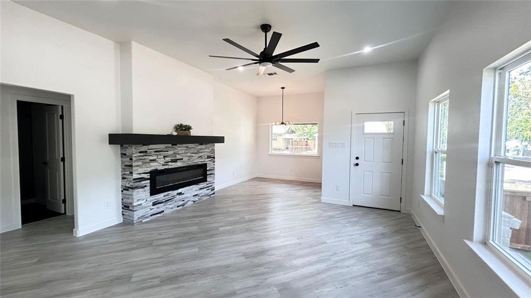 Living room with a fireplace, ceiling fan, and hardwood / wood-style floors