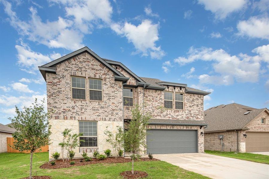 View of front of home featuring a garage and a front lawn