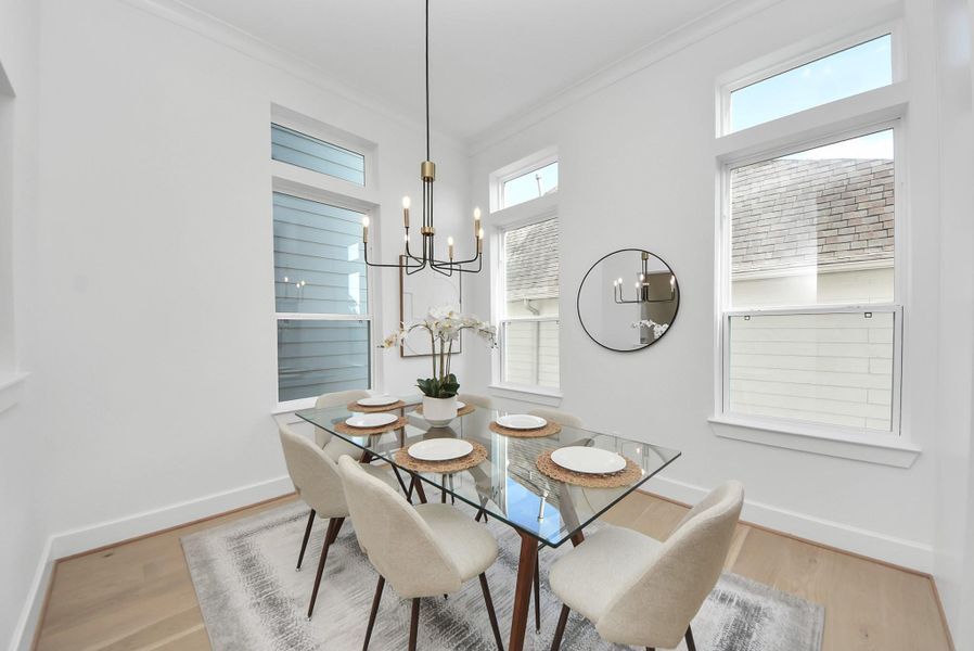 Step into this bright dining space with high ceilings and large windows, where modern decor complements a glass-top table with six upholstered chairs. A contemporary chandelier and decorative mirror add elegance, making this area both inviting and sophisticated. Step into this bright dining space with high ceilings and large windows, where modern decor complements a glass-top table with six upholstered chairs. A contemporary chandelier and decorative mirror add elegance, making this area both inviting and sophisticated.