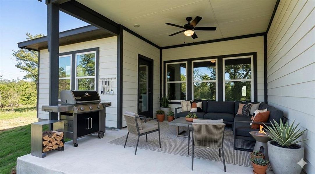 Covered outdoor patio featuring a ceiling fan, concrete flooring, exterior siding, and multiple windows with dark trim