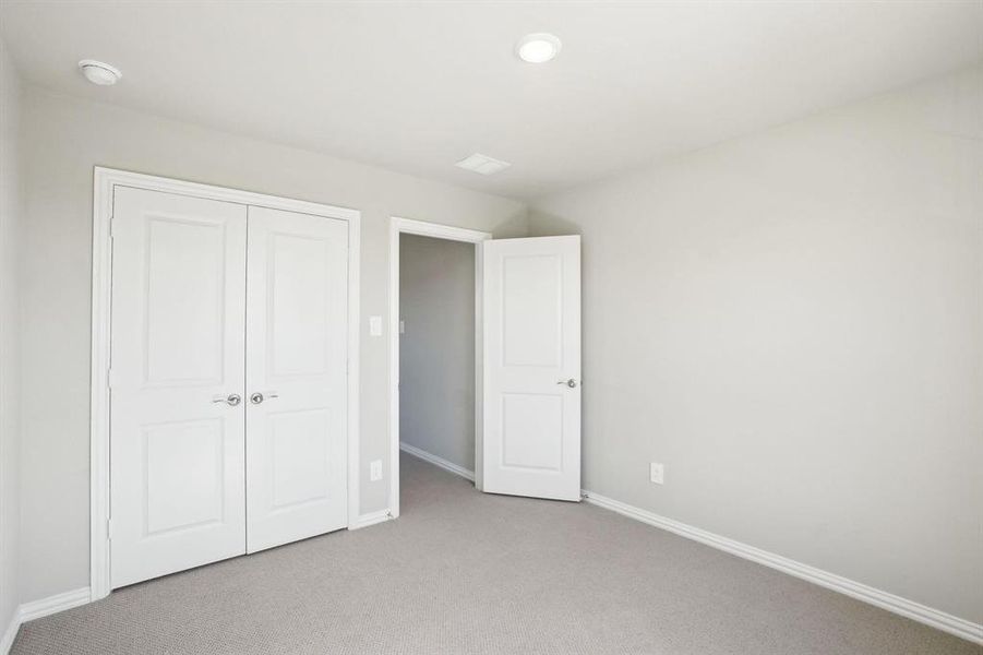 Unfurnished bedroom with carpet flooring and a closet Unfurnished bedroom with carpet flooring and a closet