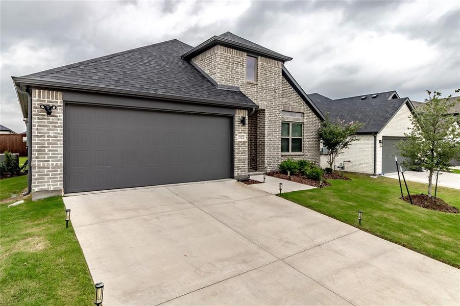 Front exterior of a new home in Devonshire, Forney, TX, highlighting curb appeal (Image 2). Front exterior of a new home in Devonshire, Forney, TX, highlighting curb appeal (Image 2).