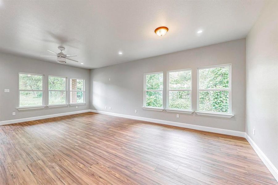 Empty room with light hardwood / wood-style flooring and ceiling fan