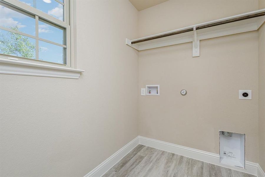 Laundry room featuring hookup for a gas dryer, electric dryer hookup, washer hookup, and light wood-type flooring