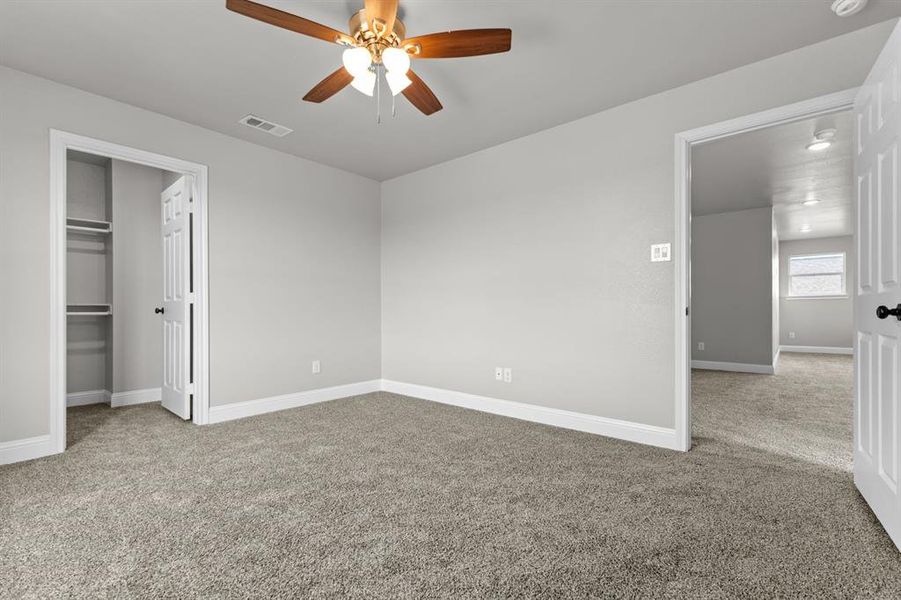 Unfurnished bedroom with carpet flooring, baseboards, a closet, and ceiling fan Unfurnished bedroom with carpet flooring, baseboards, a closet, and ceiling fan