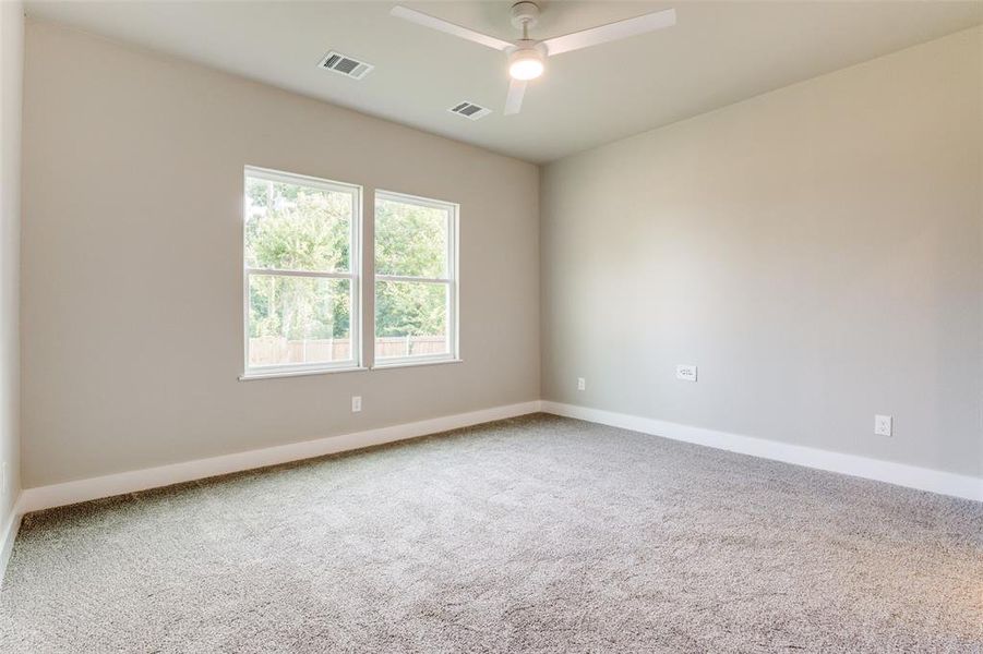 Empty room with ceiling fan and carpet floors