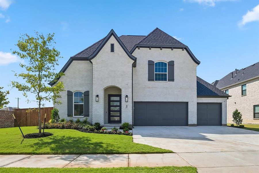 French country style house featuring brick siding, driveway, a garage, and a shingled roof