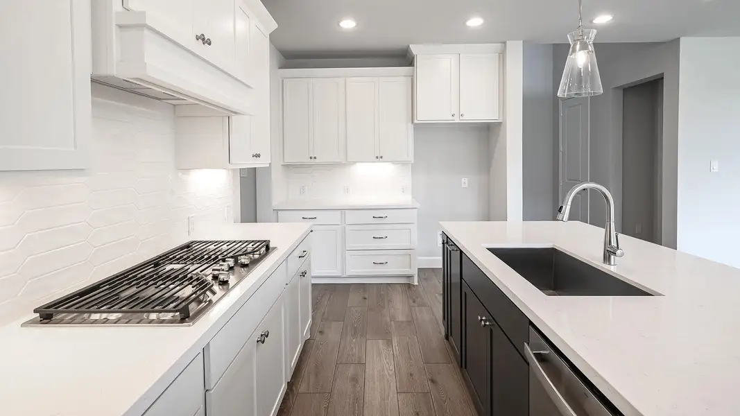 Kitchen with backsplash, dark cabinetry, white cabinets, stainless steel appliances, and dark wood-type flooring