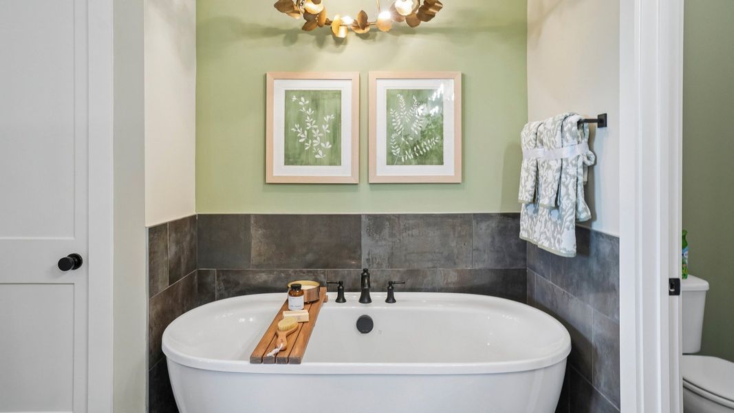 Primary bathroom with soaking tub and lighting fixture Primary bathroom with soaking tub and lighting fixture