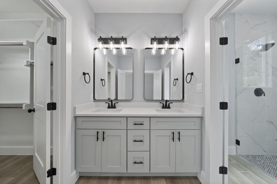 Double vanity featuring light gray cabinetry, white countertops, dual rectangular sinks, and matte black fixtures