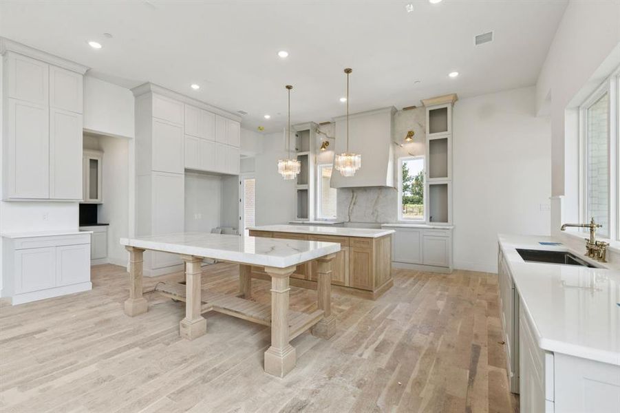 The gourmet kitchen is a true masterpiece with two oversized islands, Cristallo quartz counters, commercial grade Bertazzoni appliances, 48in dual-fuel range with 6 burners plus griddle, double oven and convection, 60in built-in refrigerator and freezer, and range hood with state-of-the-art ventilation system.