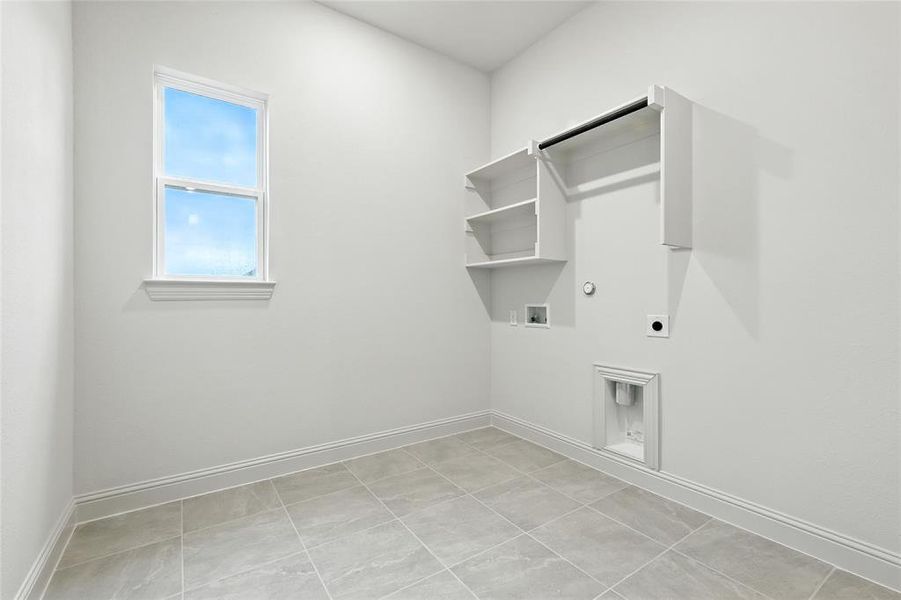 Laundry area with gas dryer hookup, electric dryer hookup, washer hookup, and light tile patterned floors