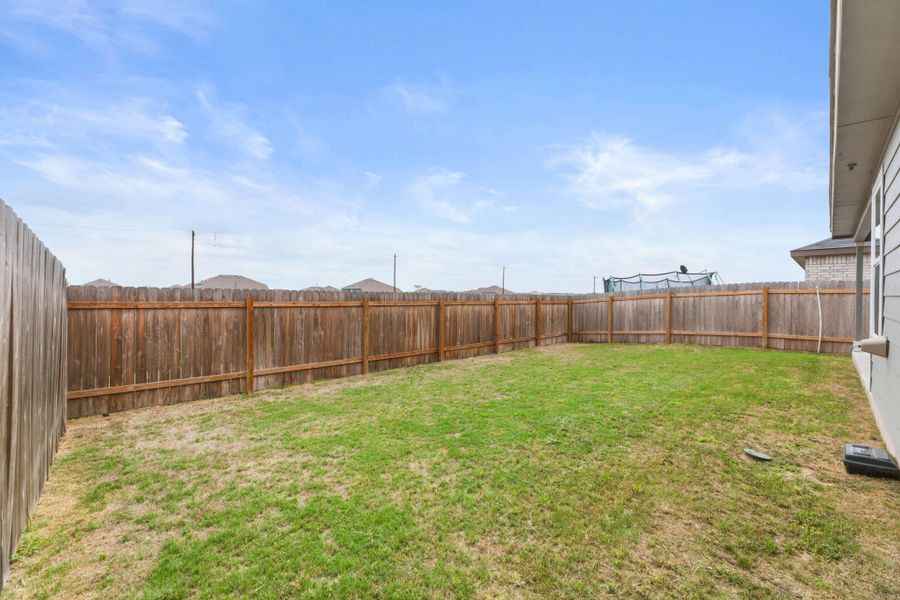 The property features a fenced backyard with a lawn