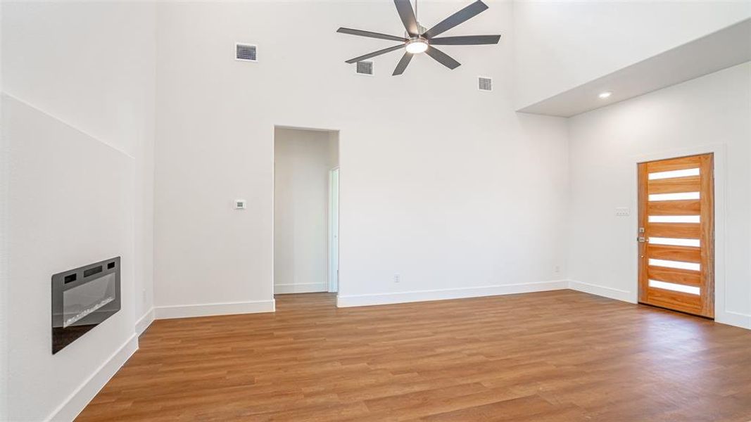 Living area with decorative fan and electric fireplace.