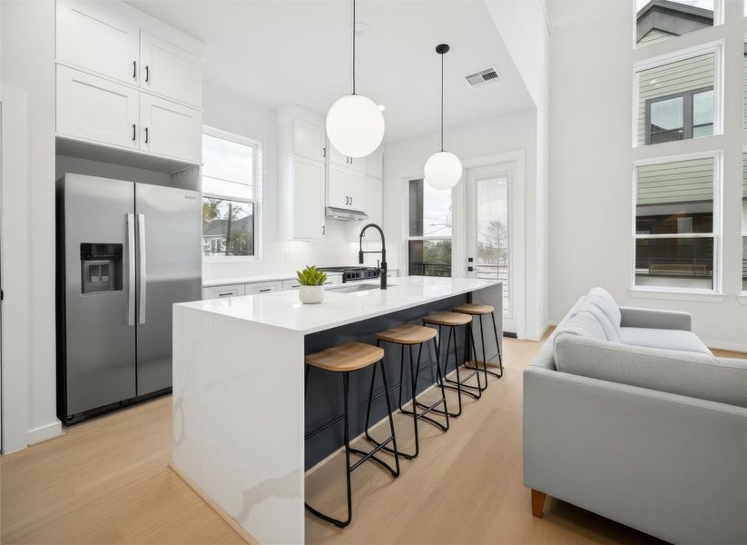 Chef inspired kitchen with sleek dark cabinetry, under-cabinet lighting, and a spacious island for gathering. *Virtually staged*