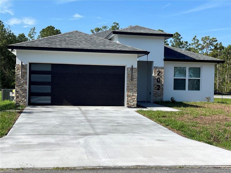 Front exterior of a new home in , Kissimmee, FL, highlighting curb appeal (Image 1).