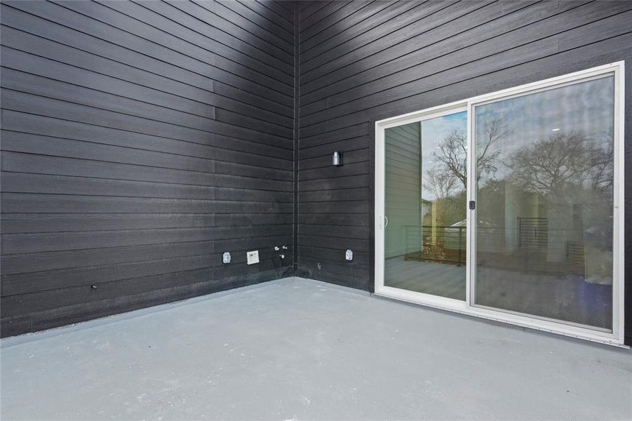 Unfurnished room featuring wooden walls and concrete flooring Unfurnished room featuring wooden walls and concrete flooring