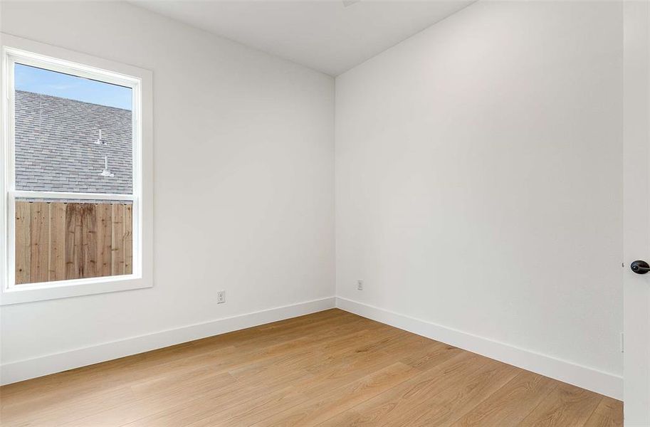 Empty room featuring baseboards and light wood-style flooring