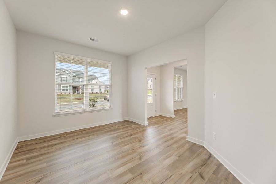 A room with a wood floor and a window. A room with a wood floor and a window.