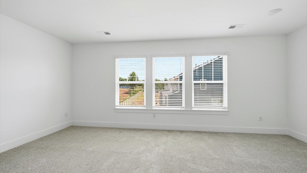 Serene and stylish primary bedroom featuring carpeted flooring and a thoughtful, modern layout at the Barton Hollow community Serene and stylish primary bedroom featuring carpeted flooring and a thoughtful, modern layout at the Barton Hollow community