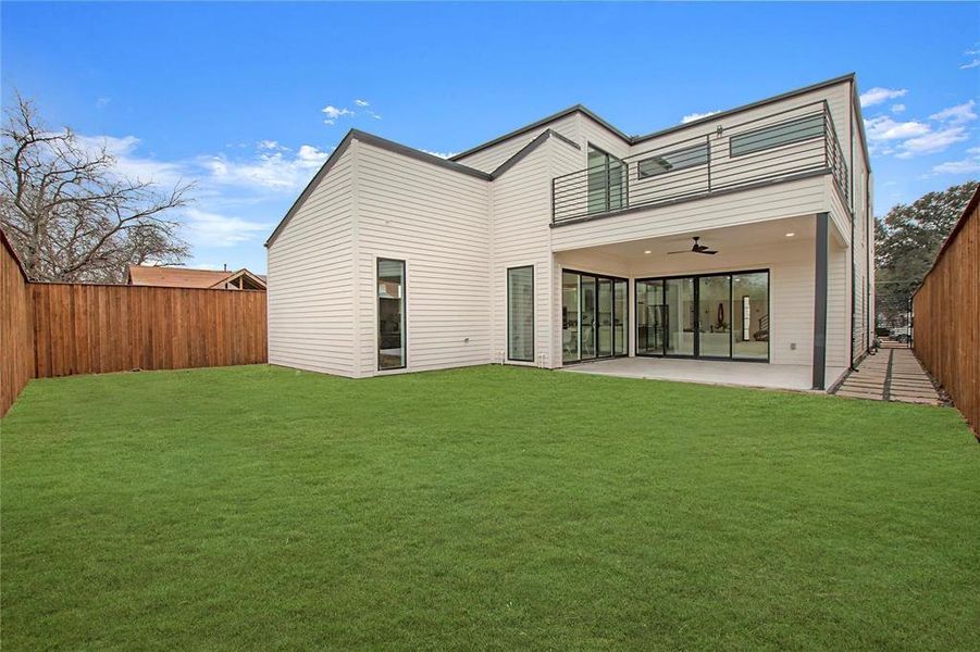 Rear view of house with a patio area, a lawn, and ceiling fan