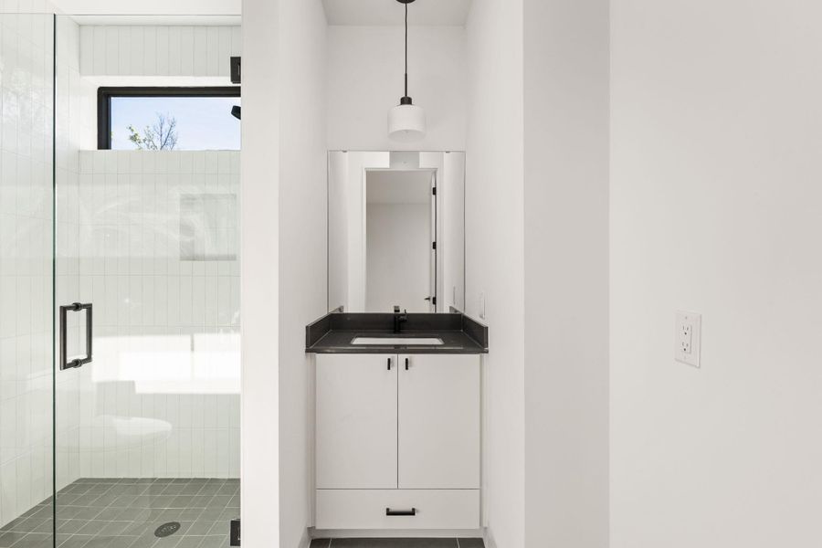 Bathroom with vanity, a stall shower, and tile patterned floors