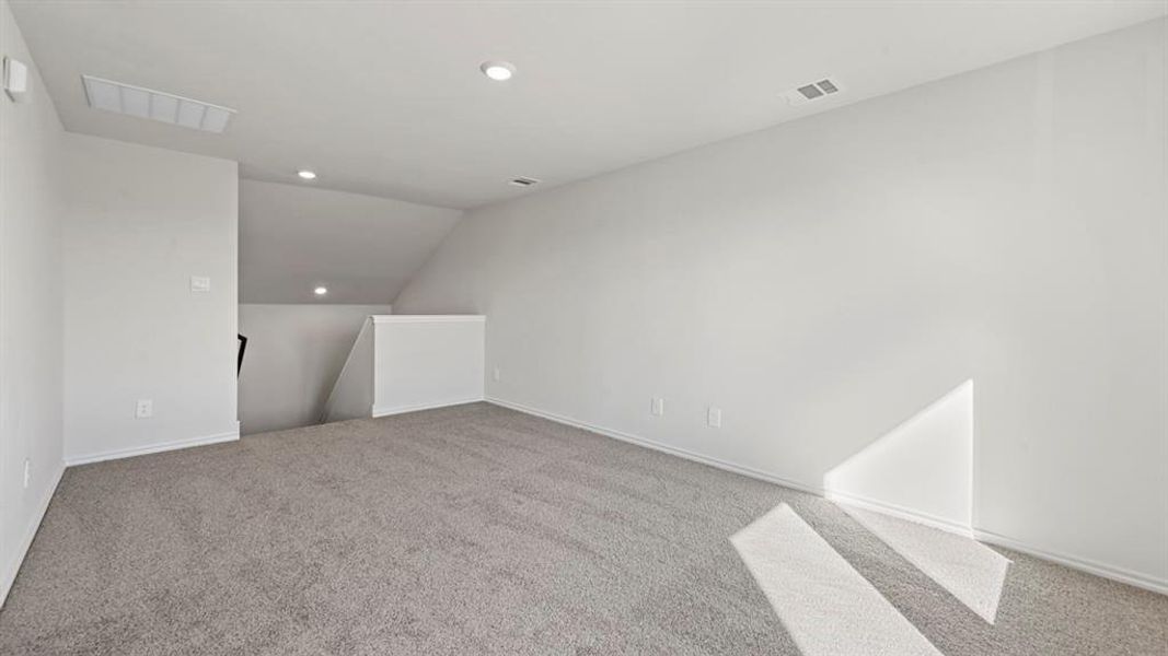 Carpeted spare room featuring lofted ceiling and recessed lighting