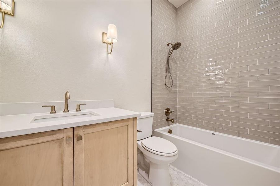 Full bathroom with tiled shower / bath, toilet, and vanity