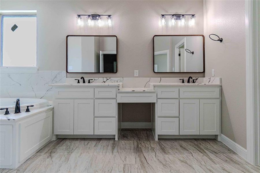 Bathroom with tile patterned flooring, a washtub, and dual bowl vanity