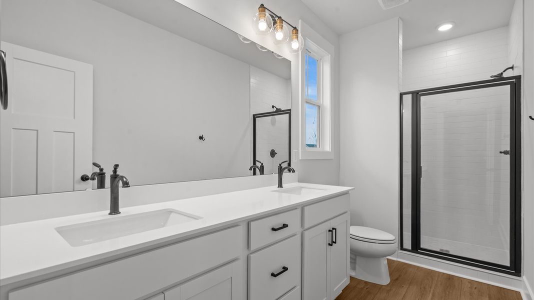 Highly functional and elegant en-suite with dual vanities, tiled walk-in shower, and refined finishes Highly functional and elegant en-suite with dual vanities, tiled walk-in shower, and refined finishes