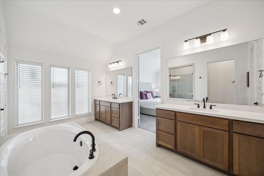 Dual vanities within the primary bathroom with a large soaking tub.