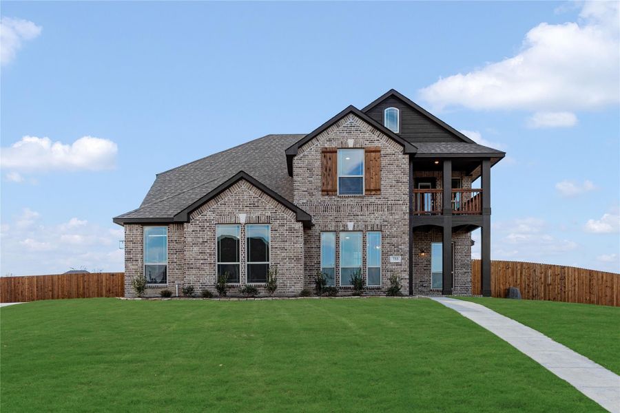 Two-story brick home with second-floor balcony, large windows, and green front lawn Two-story brick home with second-floor balcony, large windows, and green front lawn