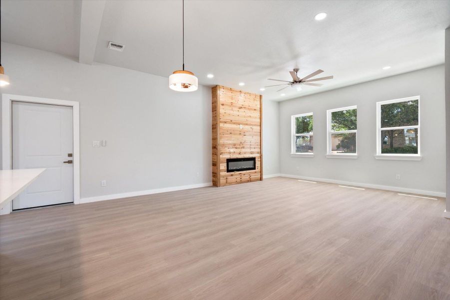 A striking cedar accent wall with an integrated fireplace anchors this well-lit, open-concept living area.